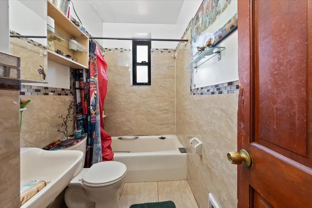 a bathroom with a toilet sink and shower curtain