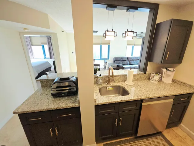 a kitchen with stainless steel appliances kitchen island granite countertop a refrigerator a stove and a sink