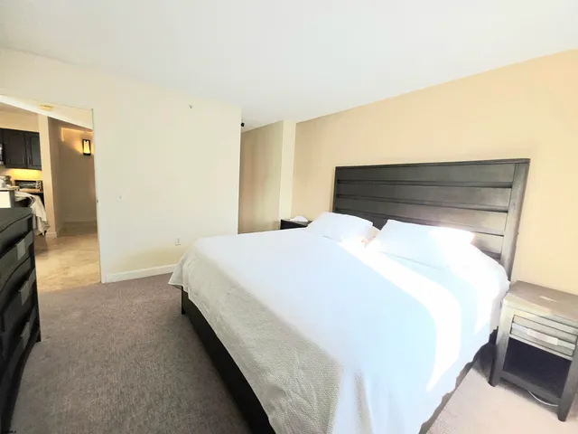 a bedroom with a bed and a tv on the dresser