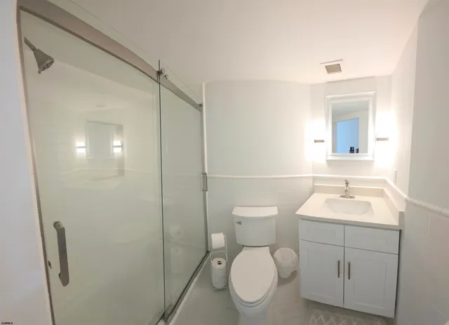 a view of a hallway with wooden floor and cabinet