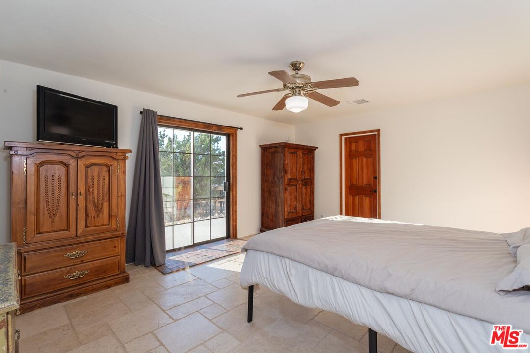 29243 Piani Road Pearblossom, CA 93553 - Photo 17 of 64 a bedroom with a bed and a television