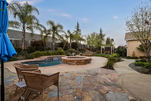 a kitchen with stainless steel appliances granite countertop a dining table chairs refrigerator and microwave