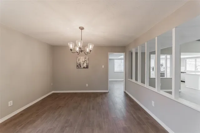 a view of a room with wooden floor and chandelier