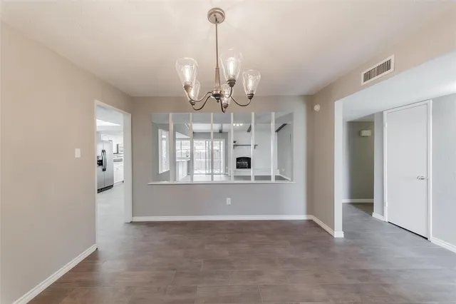 a view of livingroom with chandelier fan and kitchen view