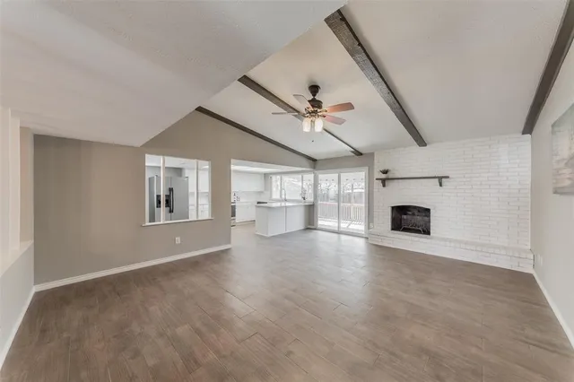 an empty room with fireplace fan and windows
