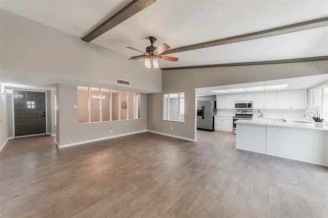 a view of an empty room with window and cabinet