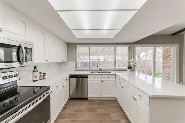 a large white kitchen with a large window