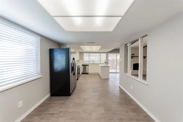 a view of a refrigerator in kitchen and empty room
