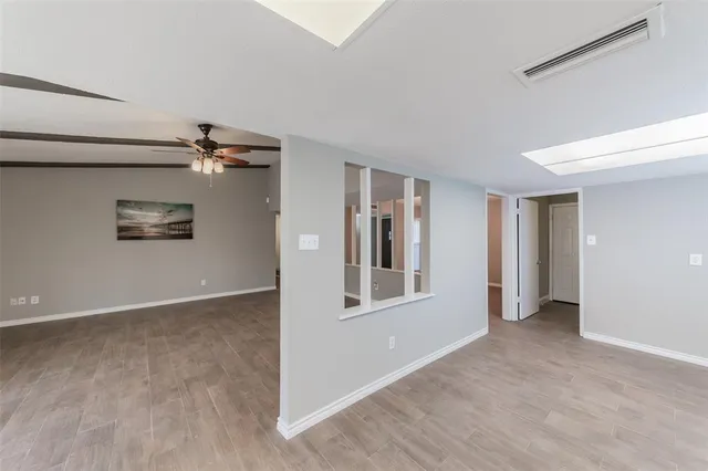 a view of a big room with wooden floor and windows