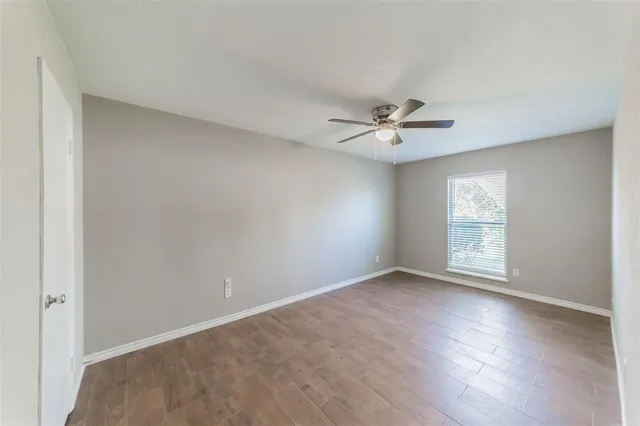 an empty room with fan and windows