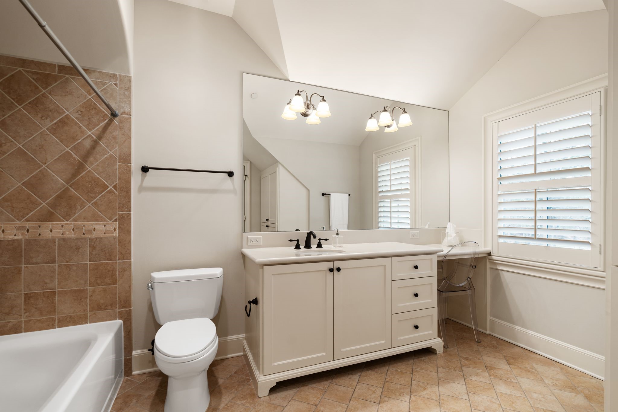 11402 Taylorcrest Road Houston, TX 77024 - Photo 27 of 44 Private en suite bath for secondary bedroom #1 features a tub/shower combination, vanity w/ storage & dedicated vanity knee space. A window w/ plantation shutters provides natural light, while a large walk-in closet & additional linen storage enhance everyday functionality.