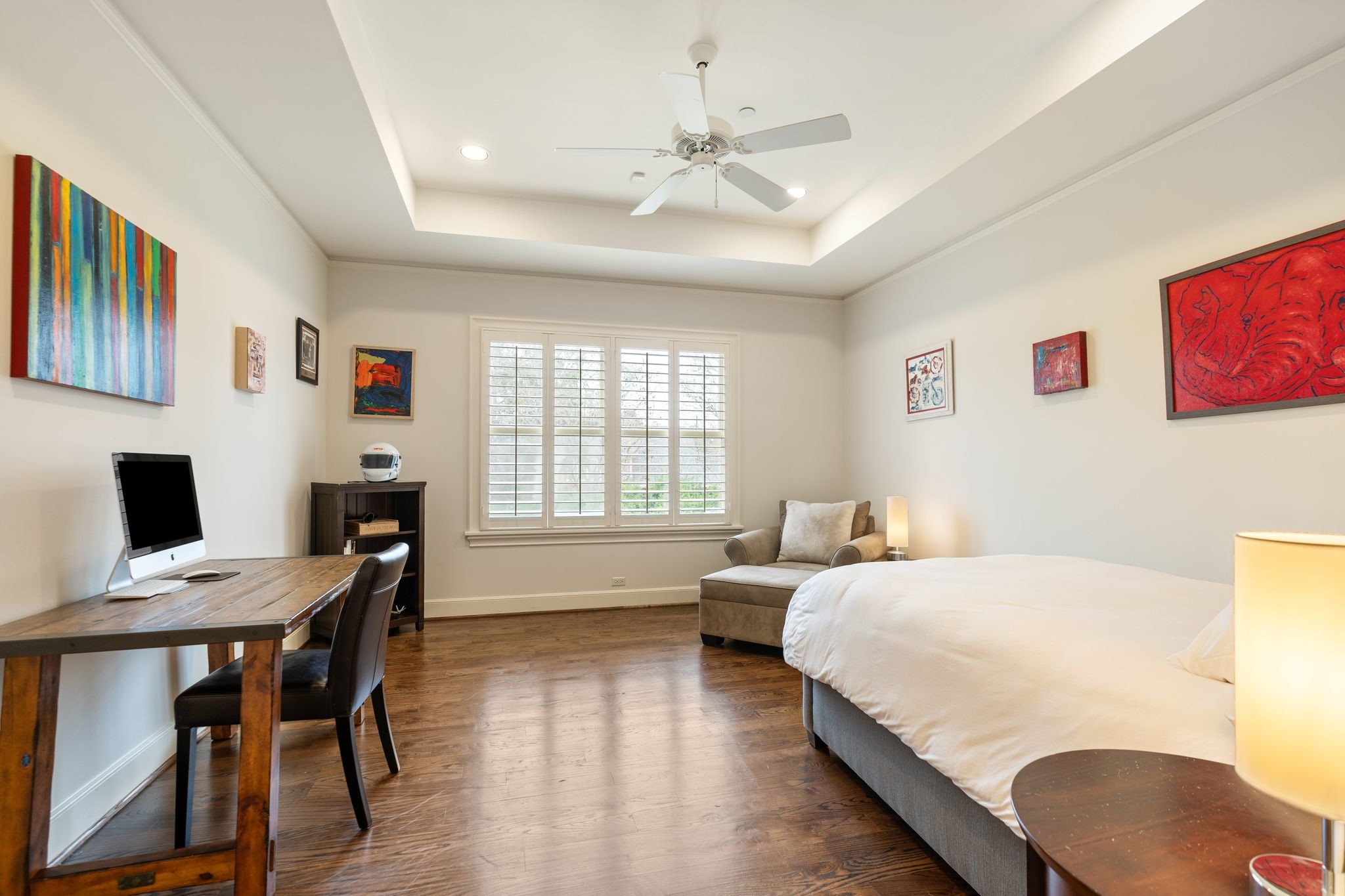 11402 Taylorcrest Road Houston, TX 77024 - Photo 30 of 44 Secondary bedroom #3 highlighted by a tray ceiling, recessed lighting & hardwood flooring. Plantation shutters add architectural charm while allowing beautiful natural light. A comfortable & versatile space suitable for a bedroom, study or guest retreat. En suite bath is to the left.