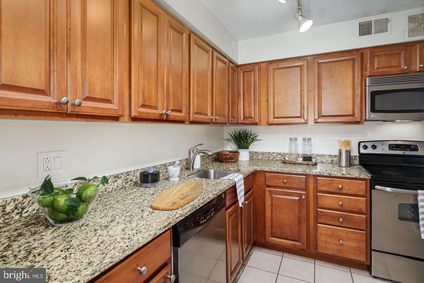 1420 Locust Street, Unit 11D Philadelphia, PA 19102 - Photo 5 of 20 a kitchen with stainless steel appliances granite countertop a sink a stove and cabinets