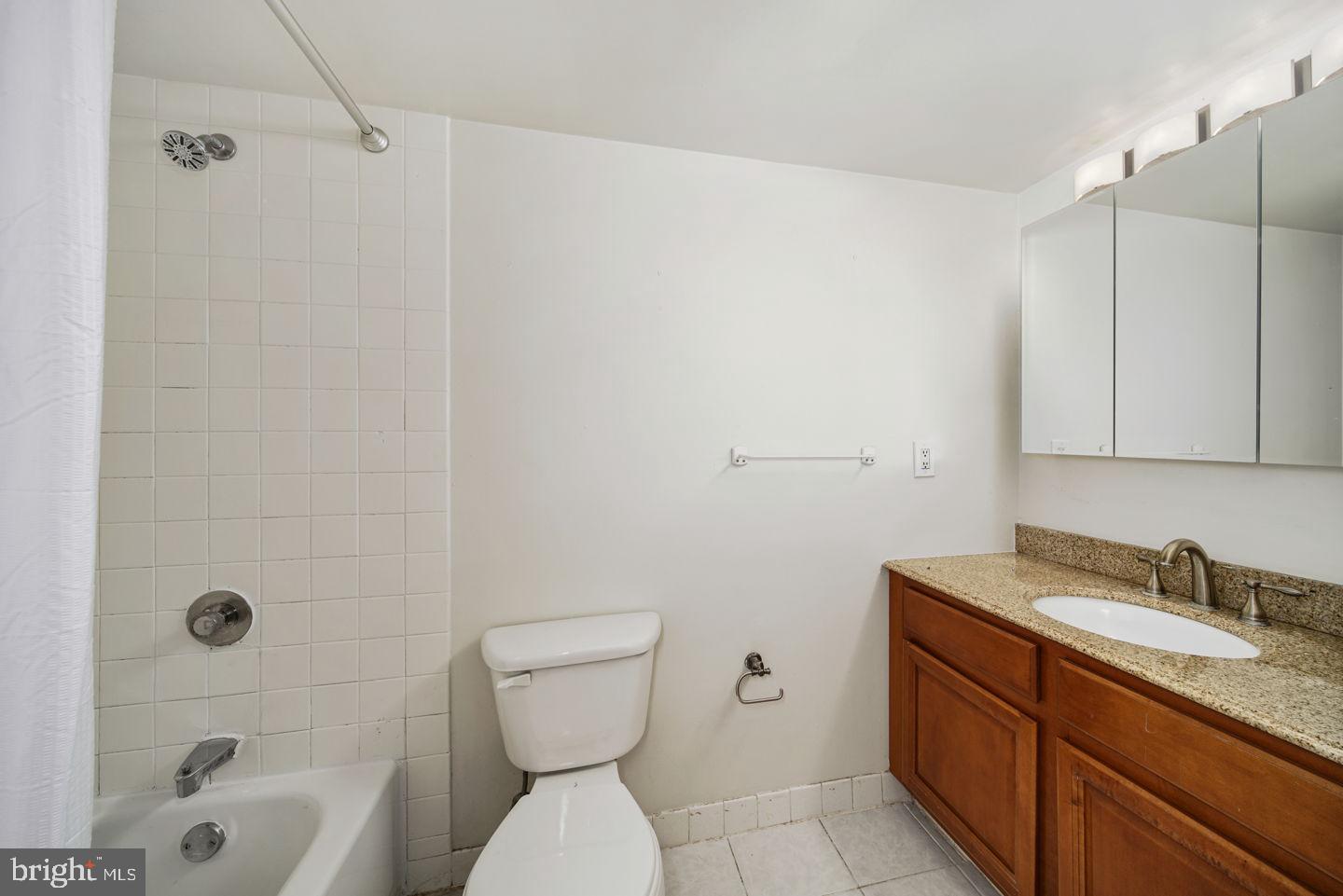 1420 Locust Street, Unit 11D Philadelphia, PA 19102 - Photo 8 of 20 a bathroom with a granite countertop toilet a sink and a bathtub