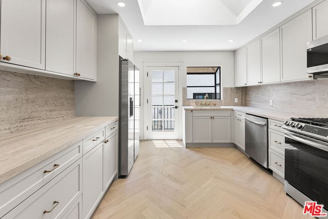 a kitchen with granite countertop white cabinets and stainless steel appliances