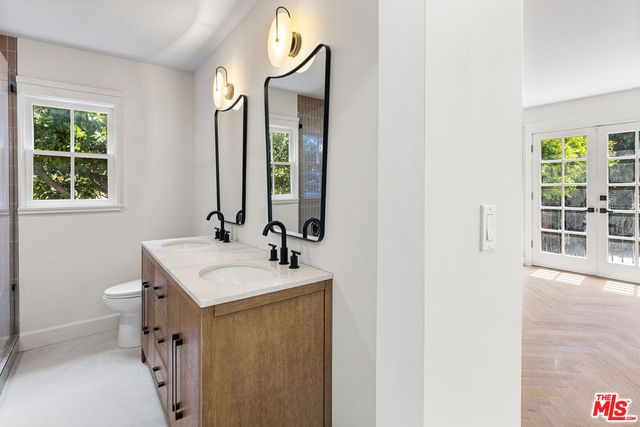 a bathroom with a sink a toilet and a mirror