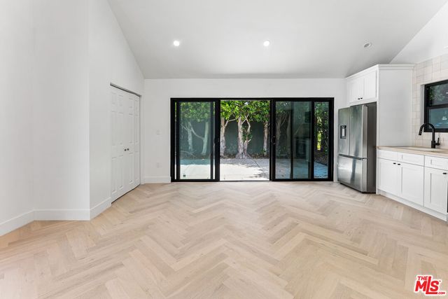 a view of an empty room with a sliding door and balcony