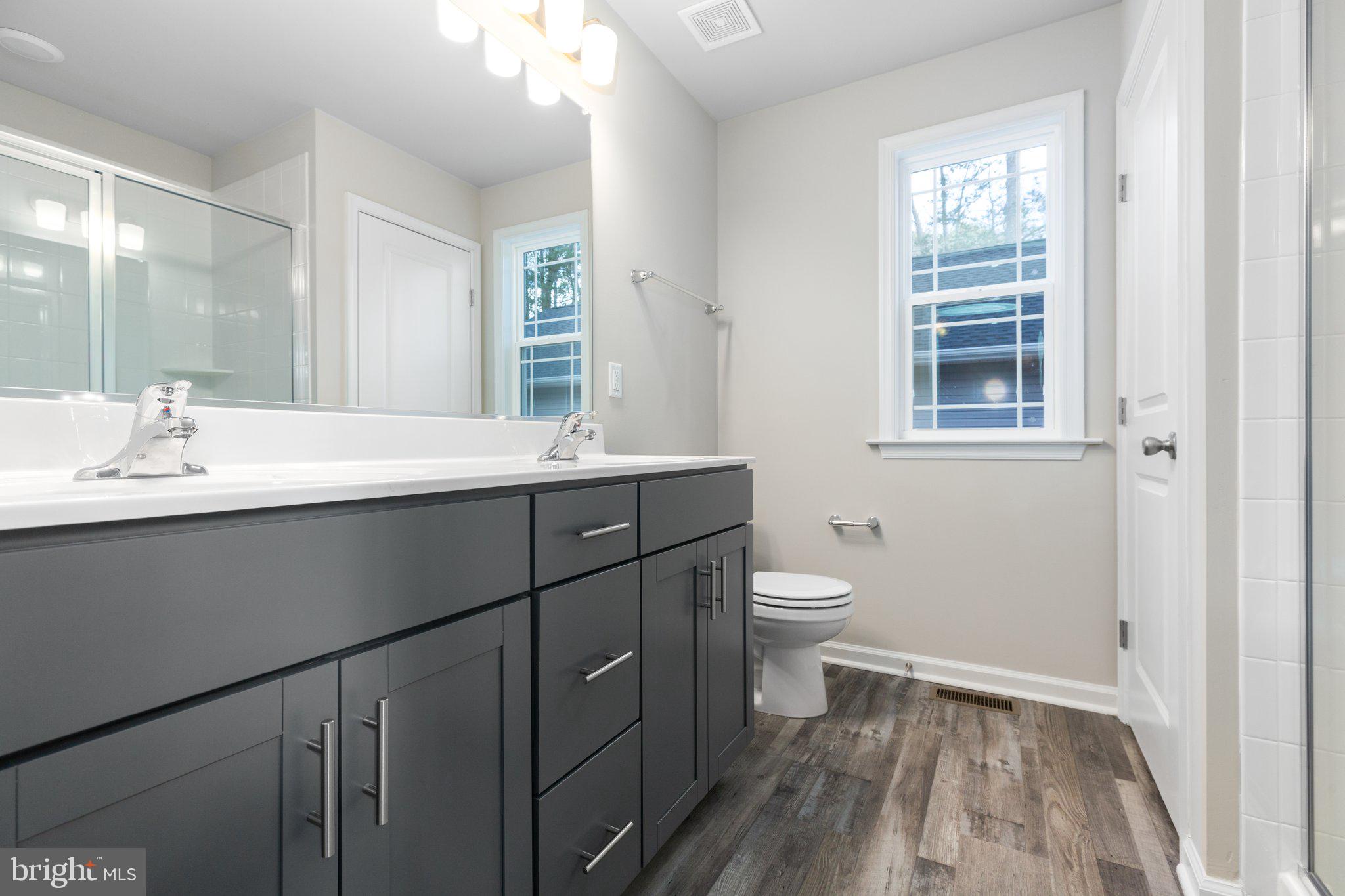 10 Azalea Way Colonial Beach, VA 22443 - Photo 27 of 36 a bathroom with a sink a toilet and a mirror