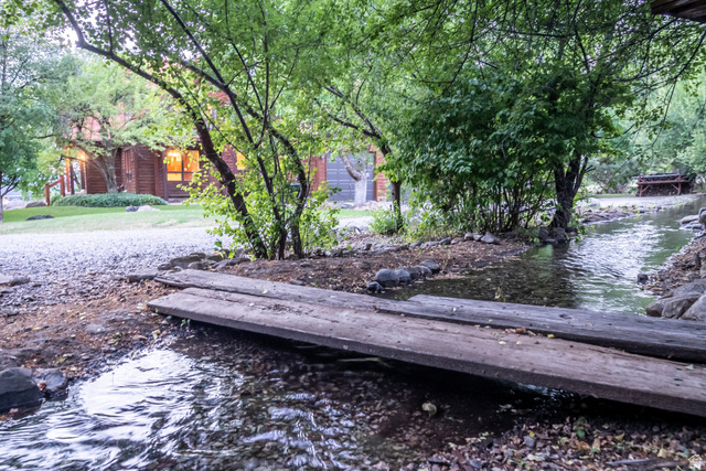 435 Canyon Road Millville, UT 84326 - Photo 78 of 113 Natural stream with a rustic wood bridge, surrounded by mature trees