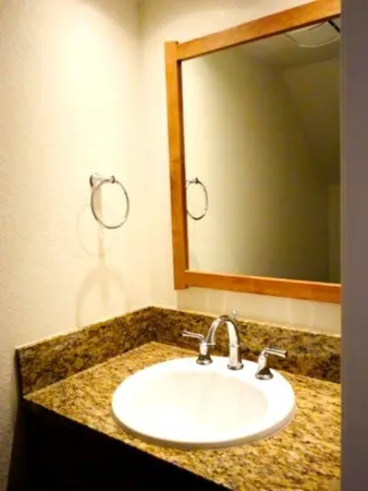 a bathroom with a granite countertop sink and a mirror