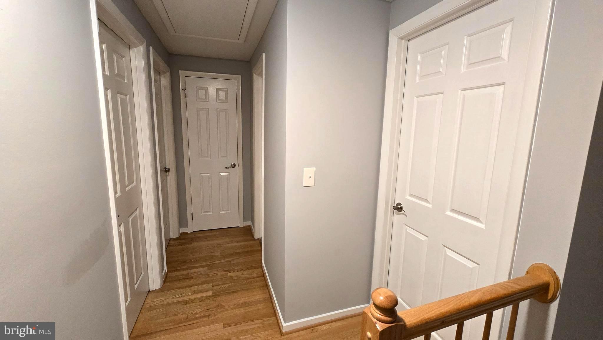 5987 Clerkenwell Court Burke, VA 22015 - Photo 16 of 41 a view of a hallway with wooden floor and staircase