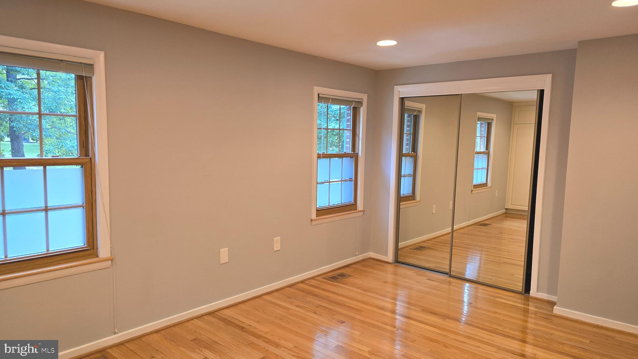 5987 Clerkenwell Court Burke, VA 22015 - Photo 20 of 41 a view of an empty room with window and wooden floor