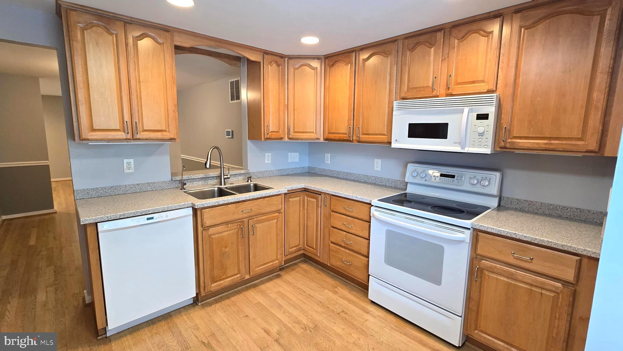 5987 Clerkenwell Court Burke, VA 22015 - Photo 5 of 41 a kitchen with stainless steel appliances granite countertop a sink a stove and cabinets