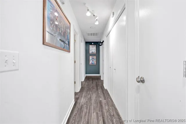 a view of a hallway with wooden floor and staircase