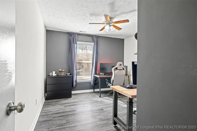 a view of workspace with wooden floor and ceiling fan