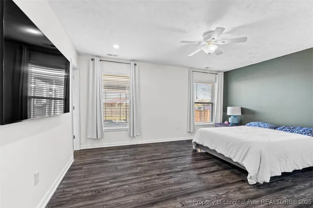 a bedroom with a large bed chandelier and a window