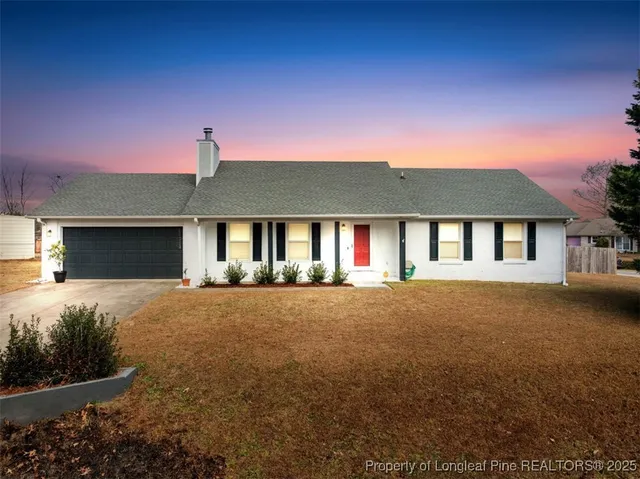 a front view of a house with yard and parking