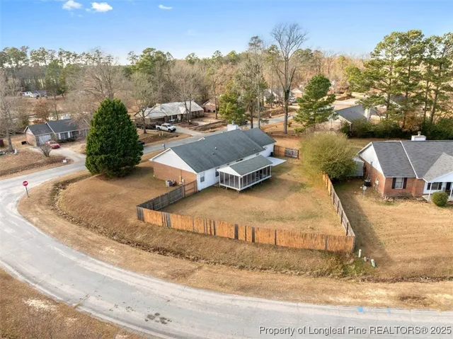 an aerial view of a house with a yard and mountain view in back
