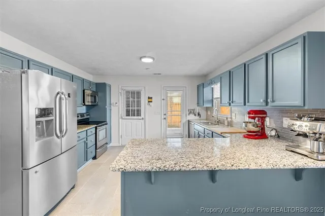 a kitchen with granite countertop a refrigerator and a sink