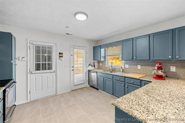 a kitchen with stainless steel appliances granite countertop a sink dishwasher stove and refrigerator