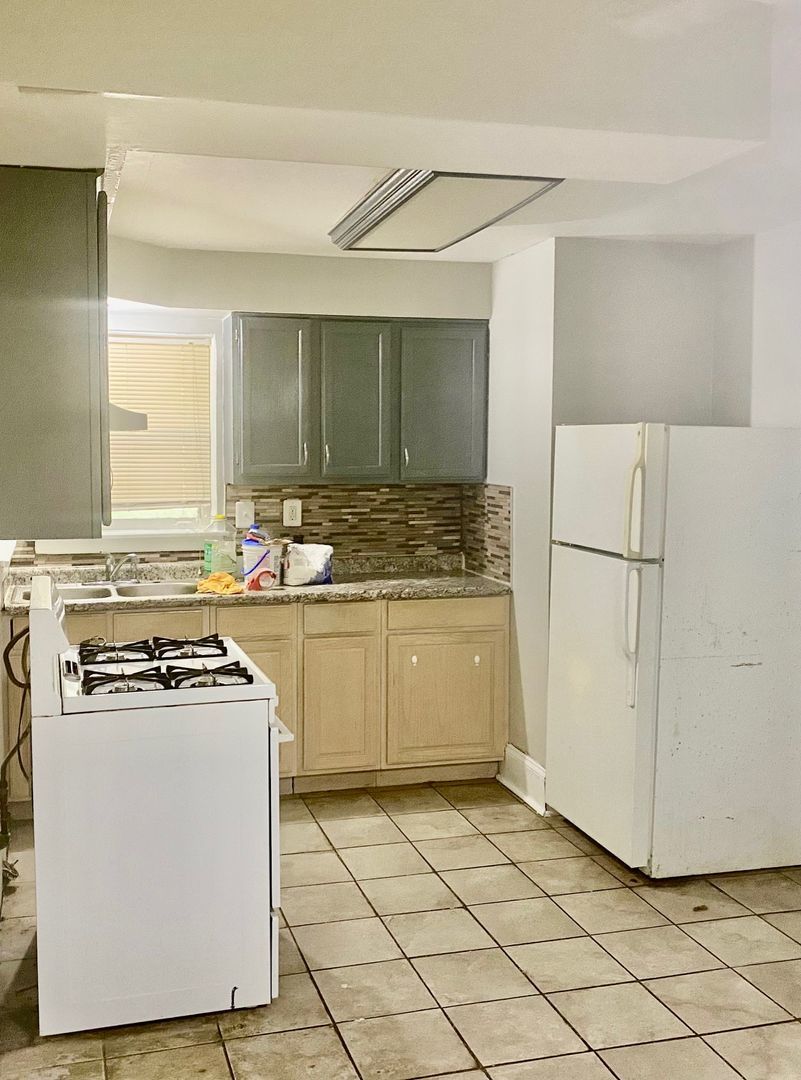 10924 South Indiana Avenue, Unit G Chicago, IL 60628 - Photo 1 of 9 a kitchen with a stove a sink and a refrigerator