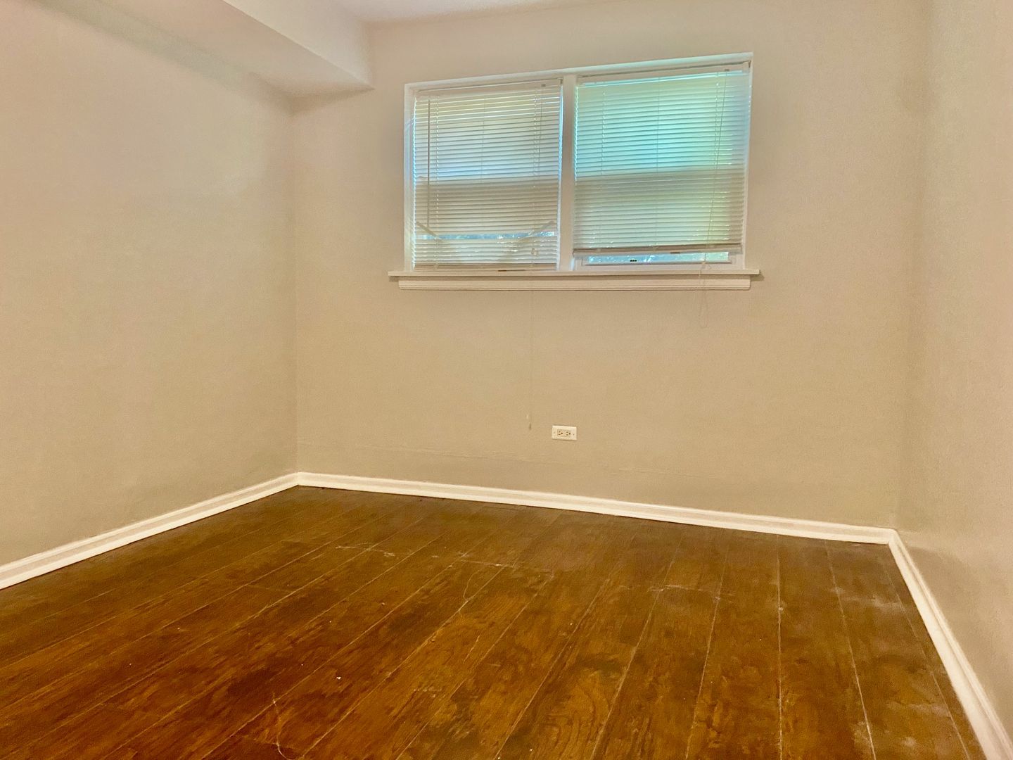 10924 South Indiana Avenue, Unit G Chicago, IL 60628 - Photo 3 of 9 an empty room with wooden floor and windows