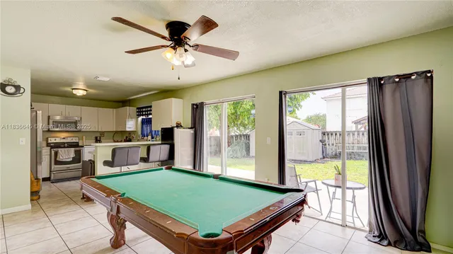 a room with pool table and windows