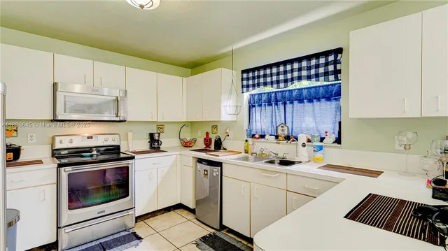 a kitchen with a sink a stove and cabinets