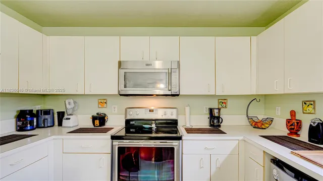 a kitchen with stainless steel appliances granite countertop a sink a stove and cabinets
