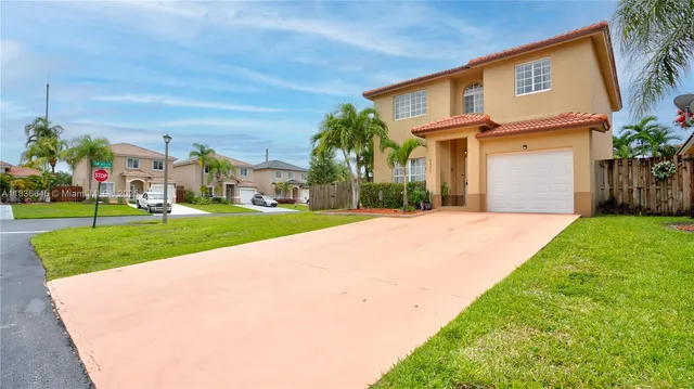 a front view of a house with a yard and potted plants