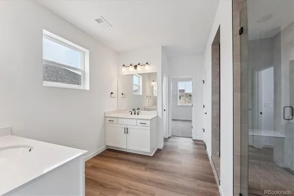 a hallway with white cabinets and wooden floor
