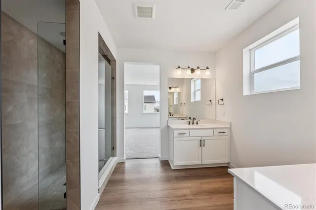 a spacious bathroom with a shower sink and mirror