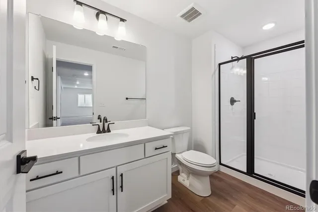 a bathroom with a sink a toilet and a large mirror