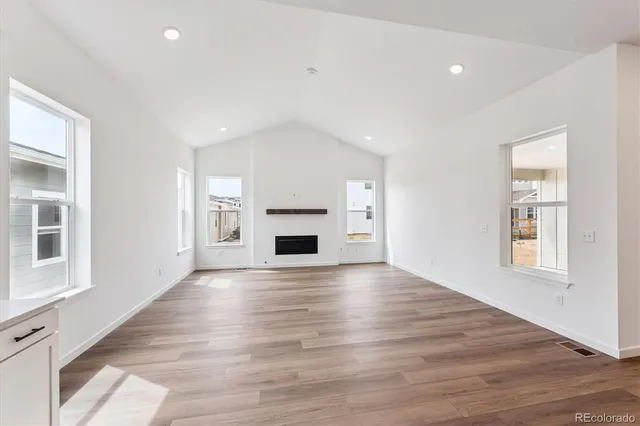 a view of empty room with wooden floor and fireplace