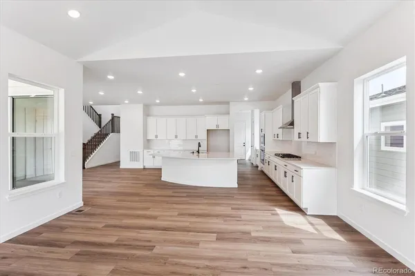 a view of kitchen with kitchen island sink stove and wooden floor