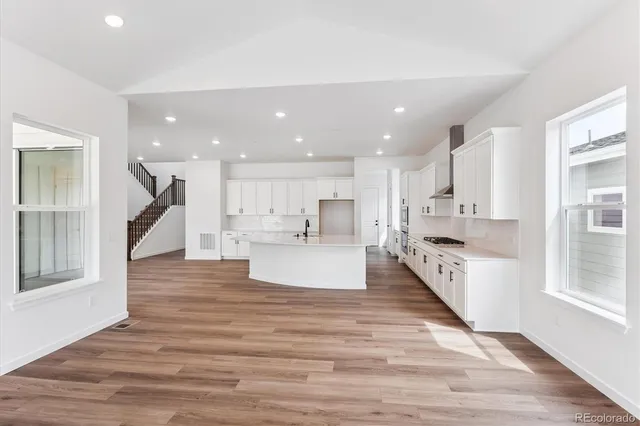 a view of kitchen with kitchen island sink stove and wooden floor