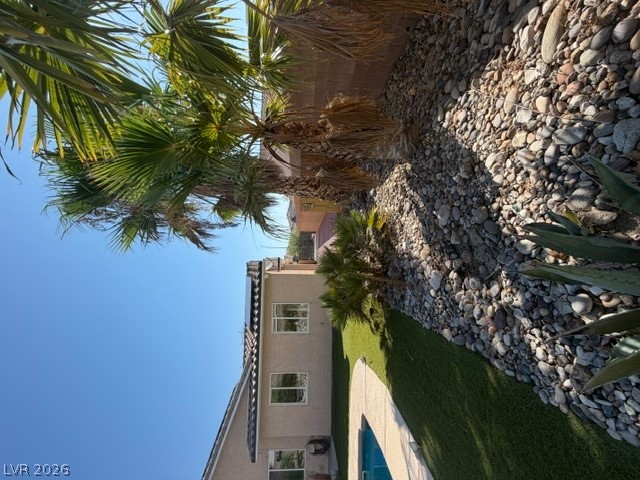 2485 Morrow Ridge Place Laughlin, NV 89029 - Photo 38 of 39 Lush palm trees and neat landscaping border a private backyard pool beneath clear skies.