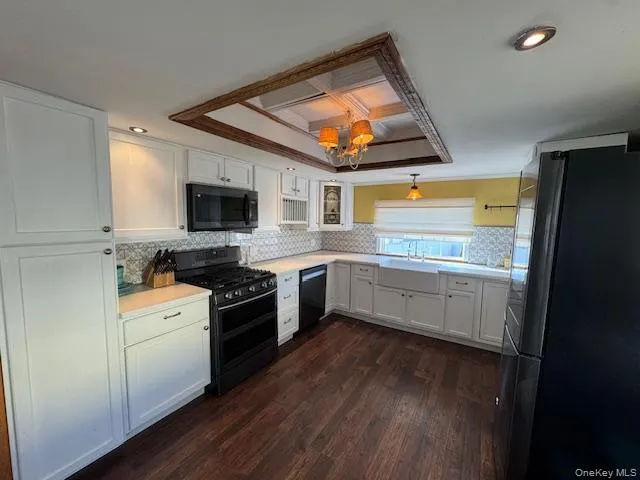 a kitchen with stainless steel appliances a stove top oven a sink and white cabinets