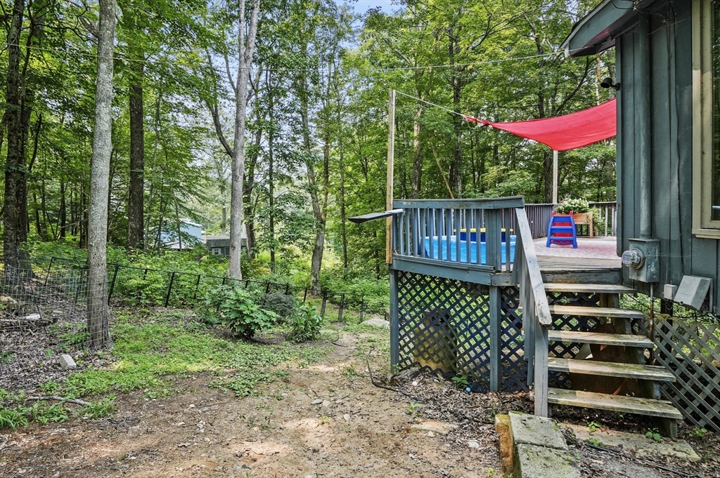 77 Vinton Road Holland, MA 01521 - Photo 23 of 31 a view of a wooden deck with chairs and large trees