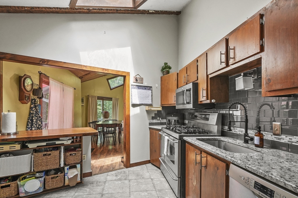 77 Vinton Road Holland, MA 01521 - Photo 9 of 31 a kitchen with stainless steel appliances granite countertop a stove a sink and a microwave